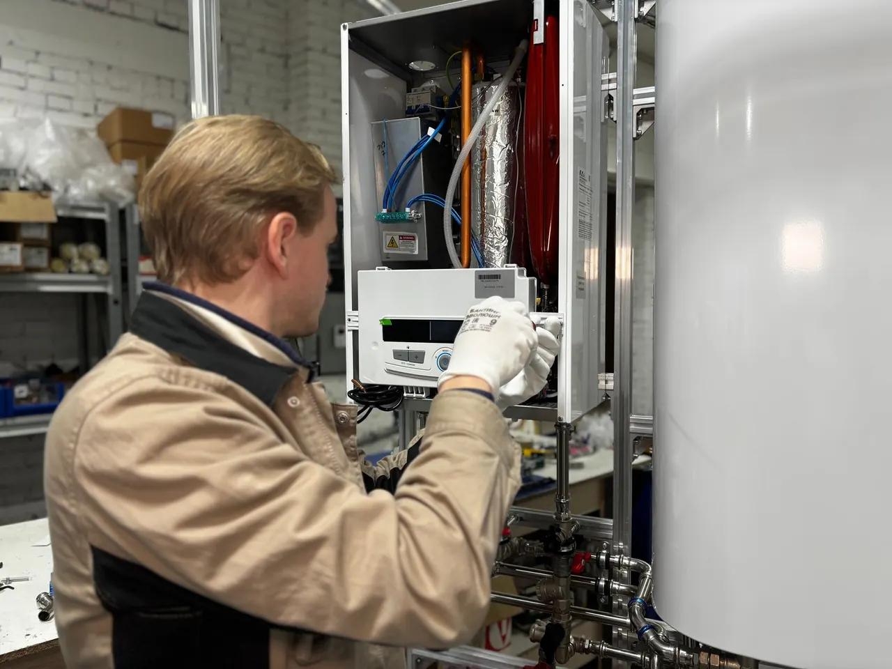 Technician checking a wall-mounted water heating unit